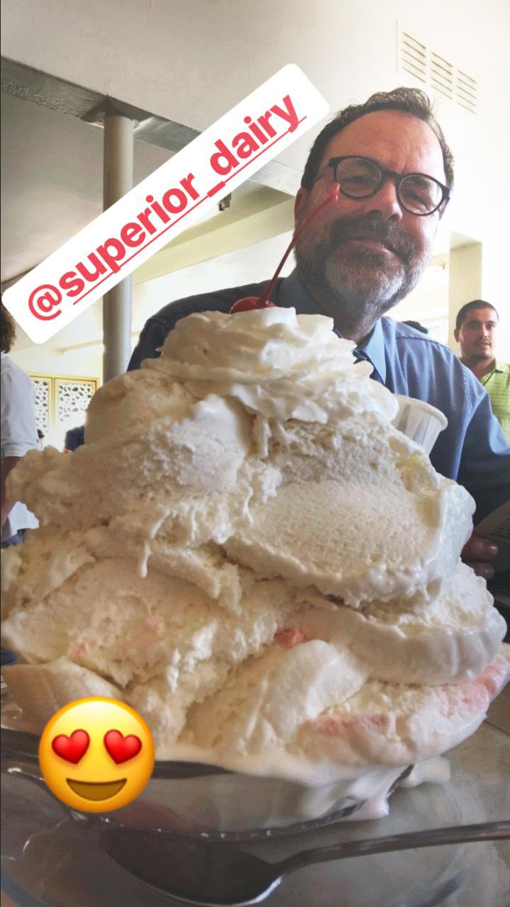 Photograph of Donald Munro in front of a giant ice cream sundae at Superior Dairy.